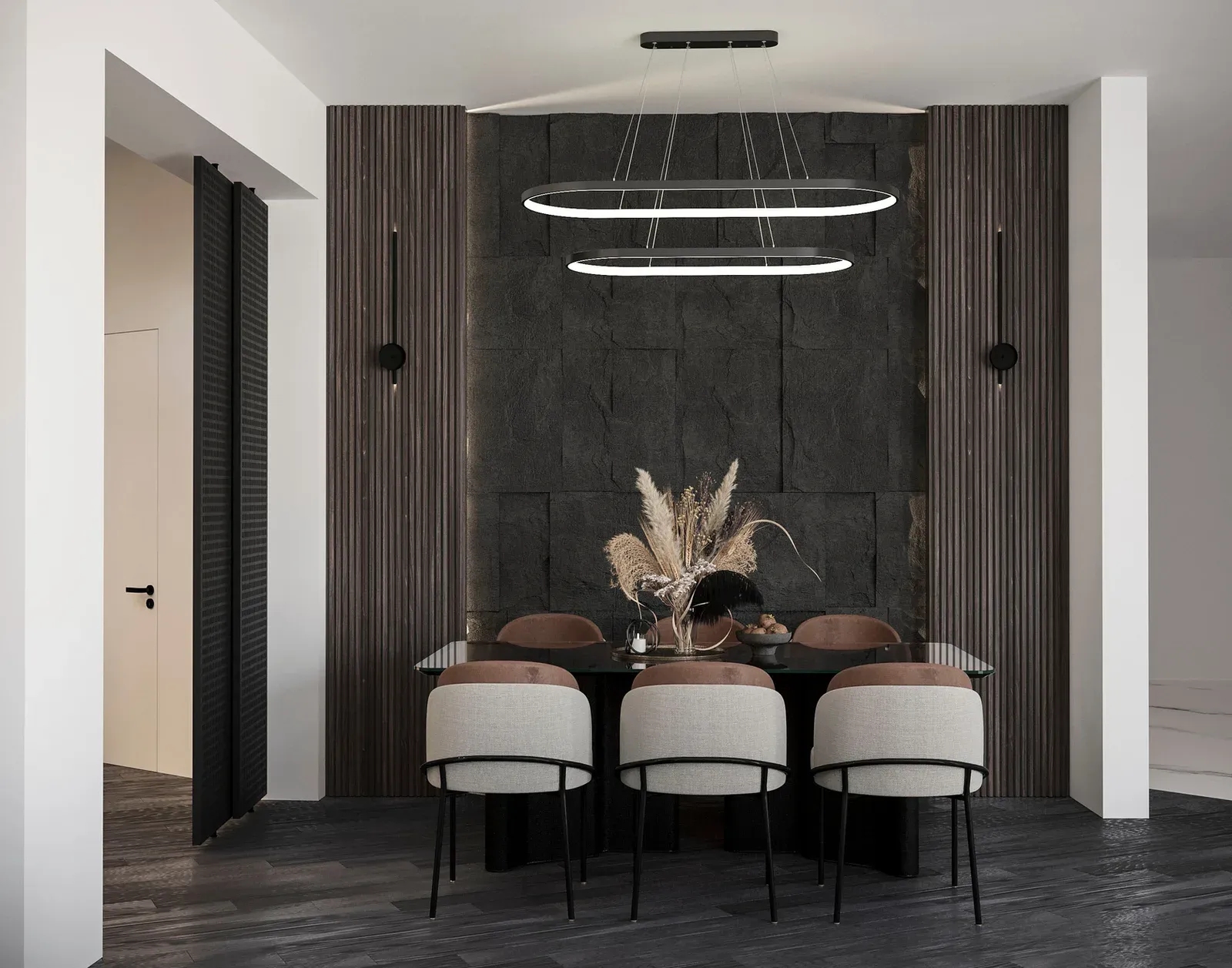 The dining table against a split-face dark stone wall flanked by fluted timber panelling, with twin ring pendants above and slim black wall lights either side.
